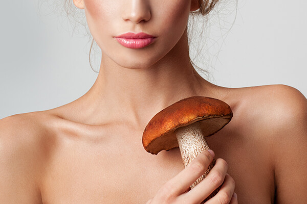 woman holding a mushroom