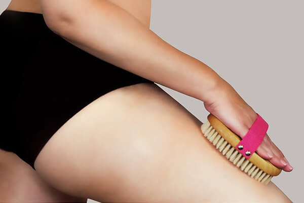 woman dry brushing thighs